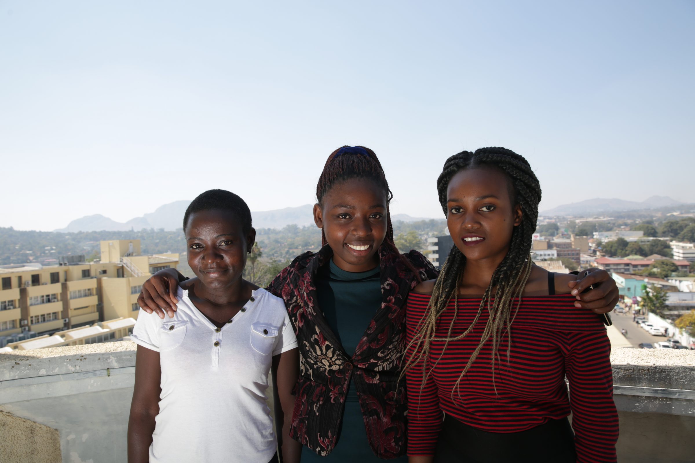 Photograph of three scholarship recipients posing together on the roof of ESCOM’s Blantyre office