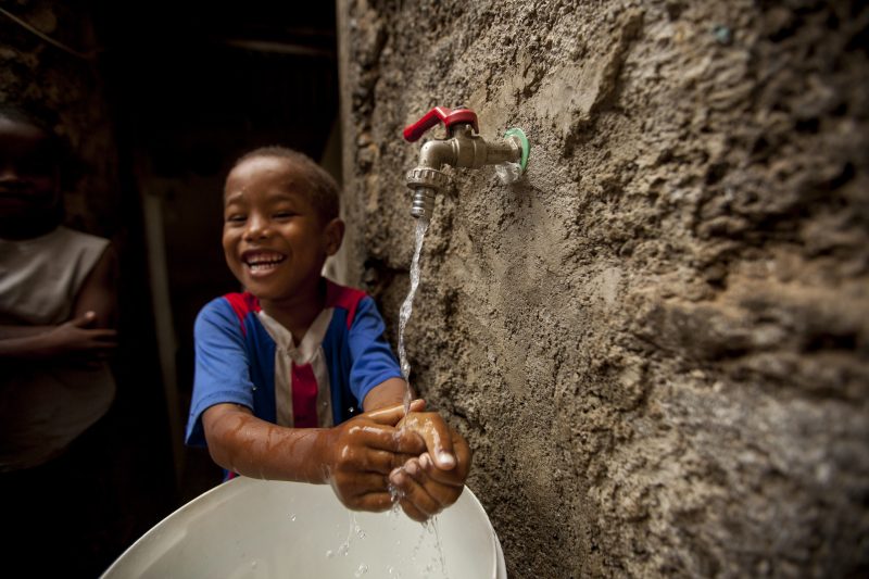 A boy in Cabo Verde enjoys running water in his home, set up as part of MCC's compact in the country.