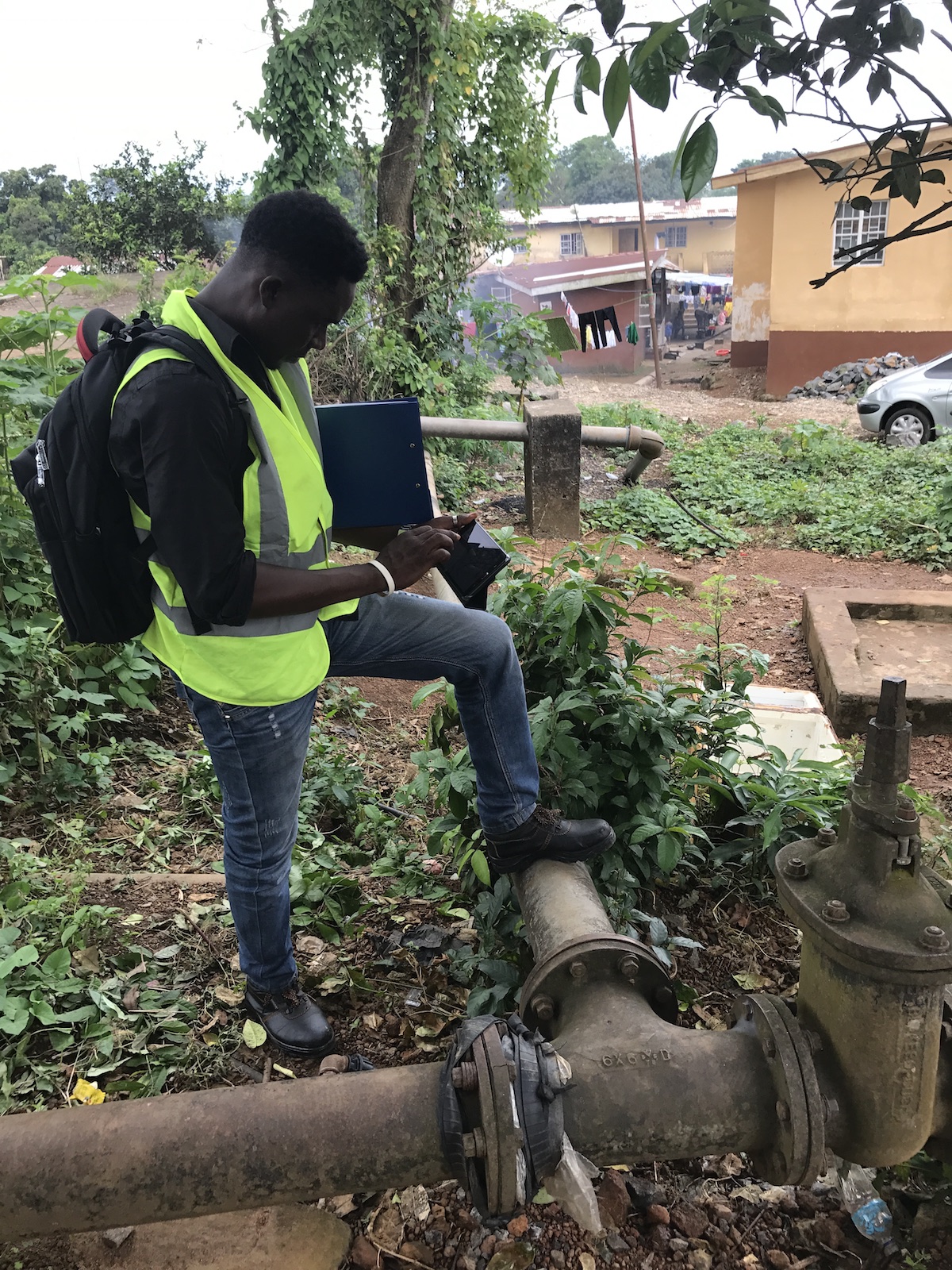 Technician Dennis Koroma maps water pipes, many of them exposed, in Freetown, Sierra Leone.