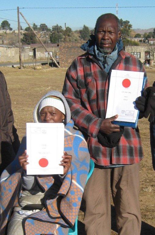 landholders holding up certificates of new leases