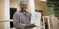 Manuel Gomes holds his newly acquired land title outside his home on the island of Maio, Cabo Verde. Mr. Gomes was able to obtain his title as a result of investments made as part of the MCC-Cabo Verde Compact that helped clarify land rights across the island nation.