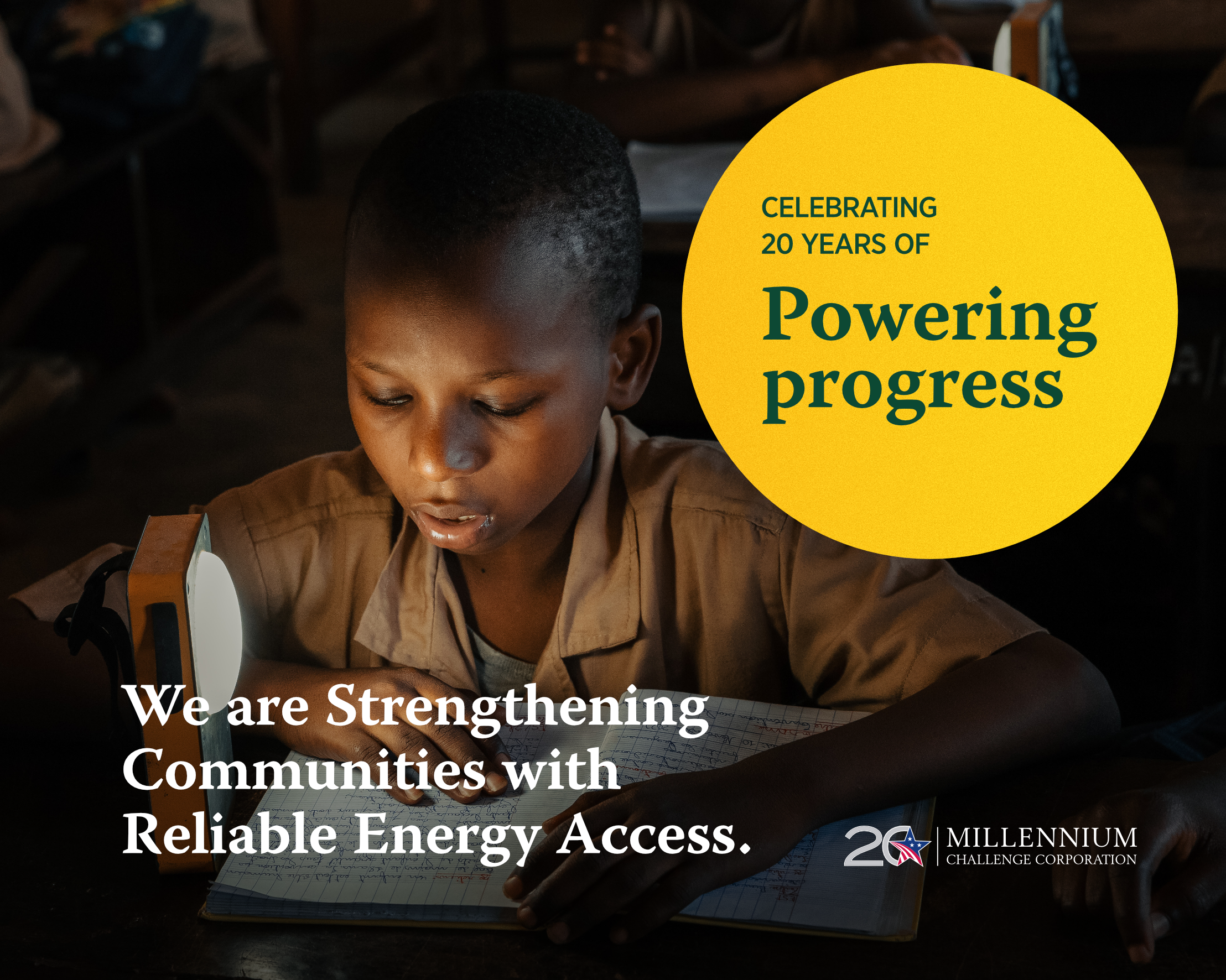 A child reads in the dark with a solar-powered light with overlaid text: Celebrating 20 years of Powering Progress. We are strengthening communities with reliable energy access.