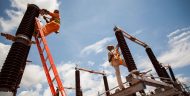 Workers servicing a substation financed by the compact.