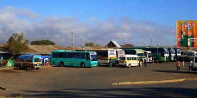 Short- and long-haul buses waiting to load passengers at the bus station in Tunduma, providing service along the Tunduma – Sumbawanga road.