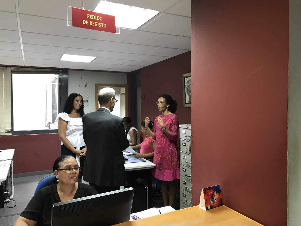 MCC Vice President for Compact Operations Robert Blau (center) talks with Praia Registry General Director for Registration and Notary Services Rita Ramos (right) and her team in Cabo Verde. As part of MCC’s investments in land management, the registry digitized its land titling records and cut down its registration certificate delivery time.