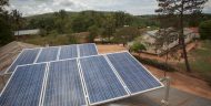 Two solar panels collect energy in Tanzania, providing energy to a nearby village.